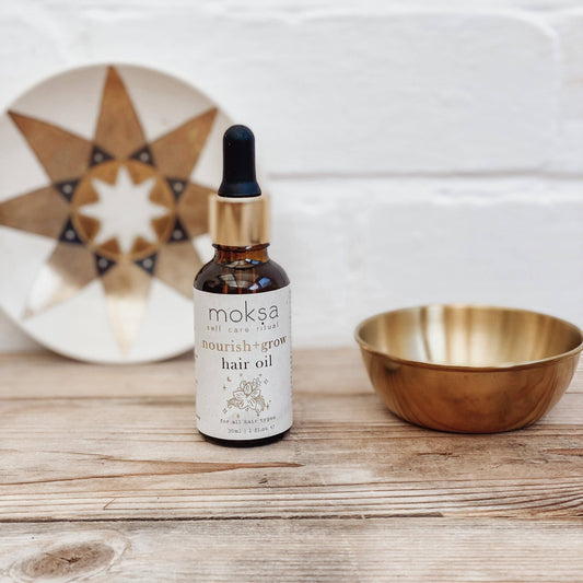 Bottle sitting on wooden table with a star plate and a gold bowl.