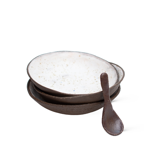 Set of ceramic bowls with a wooden spoon on a white background
