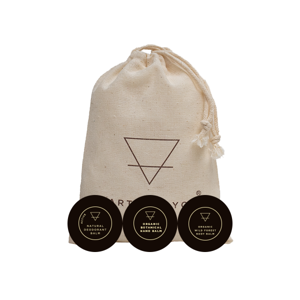 Three organic skin care balm containers with a drawstring bag featuring a logo on a white background.