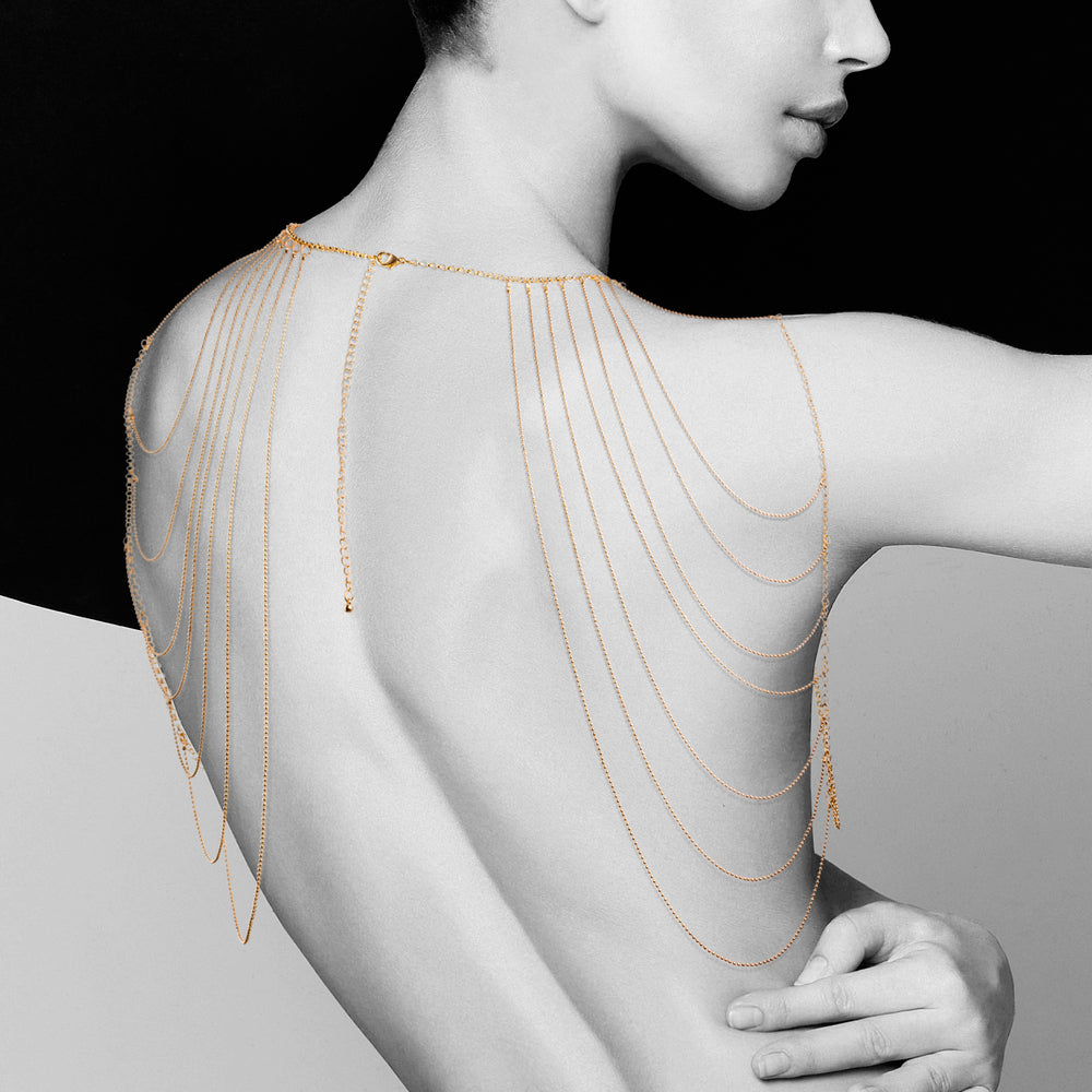 lady wearing gold shoulder chains on white and black background. image 1