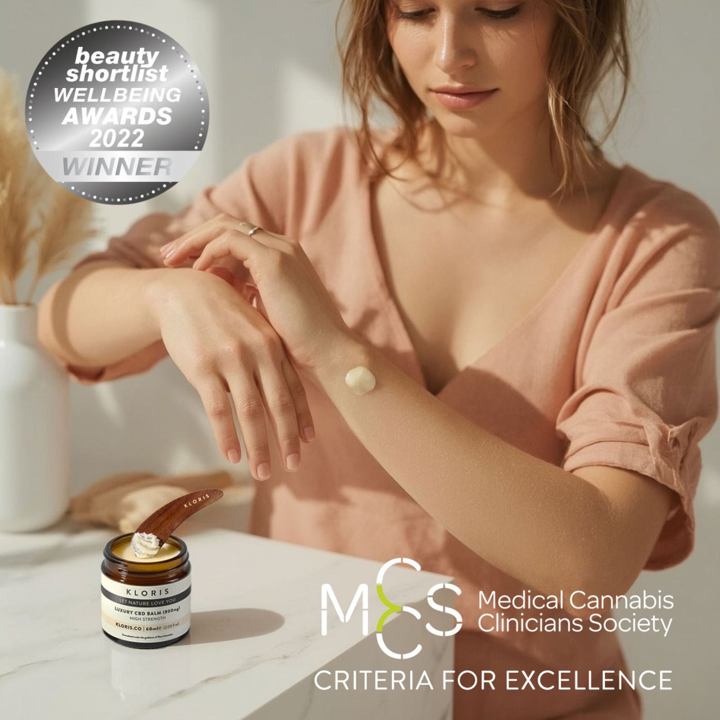 Woman applying cream to her wrist with a jar of cream on a table, surrounded by 'Medical Cannabis Clinicians Society' branding.
