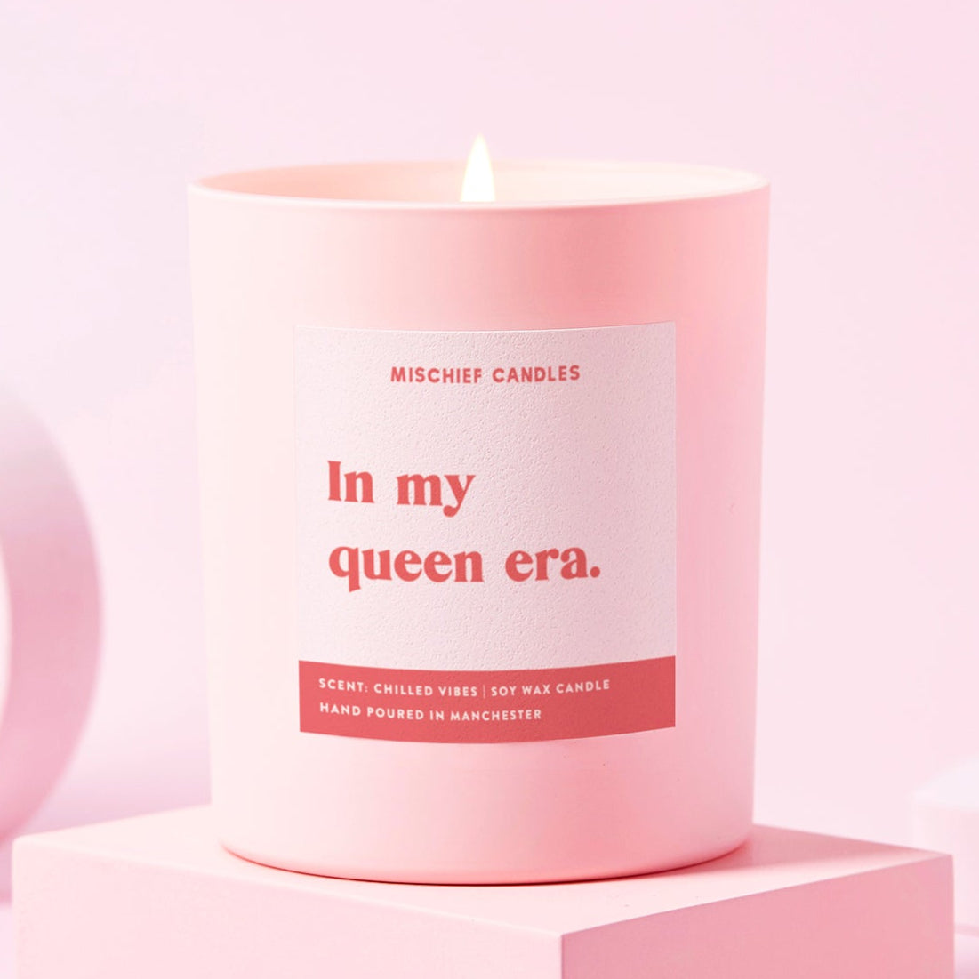 Pink candle with a label on a pink background