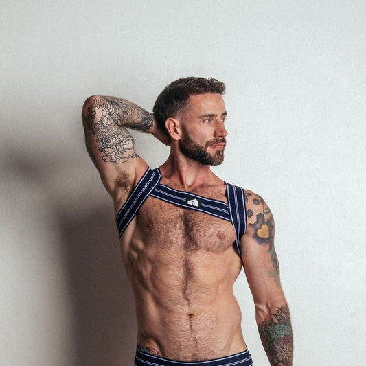 Man wearing a navy blue athletic bra and underwear set with matching socks against a plain background