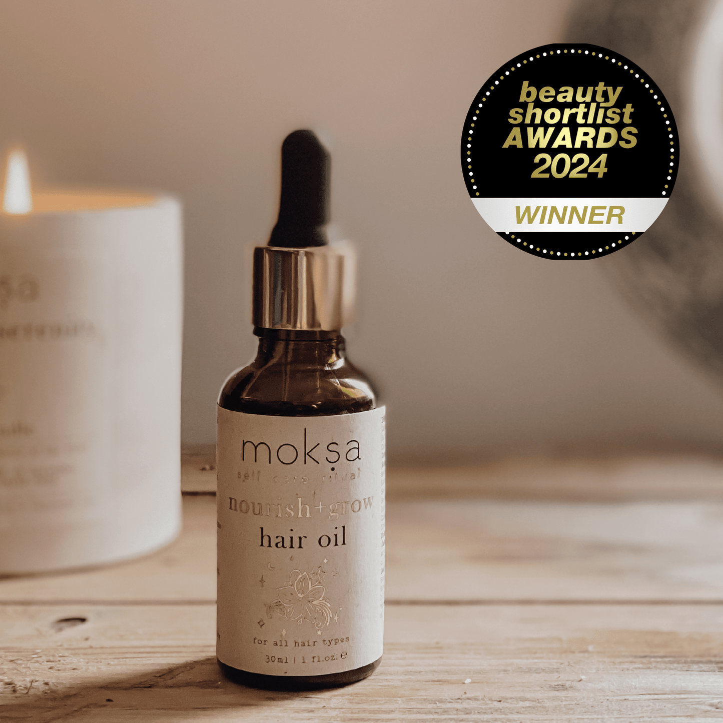 Bottle of hair oil on a wooden table with a candle in background. Also an award sticker in corner.