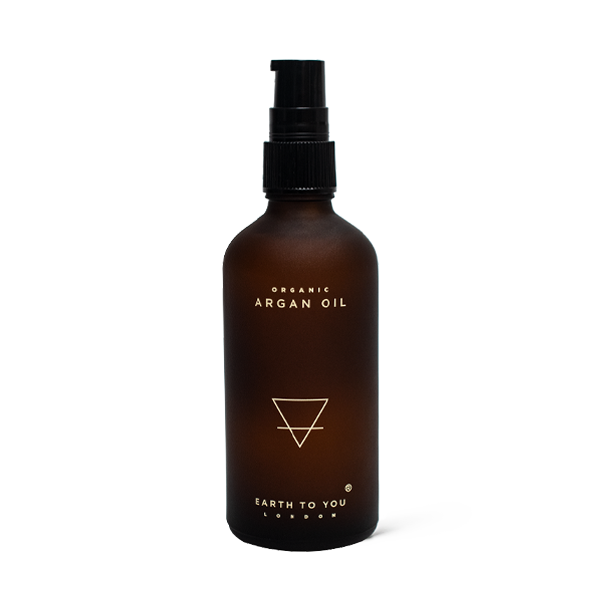 Brown bottle of organic argan oil with a black pump on a white background
