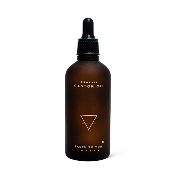 Brown glass bottle with dropper labeled 'Organic Castor Oil' by 'Earth to You London' on a white background