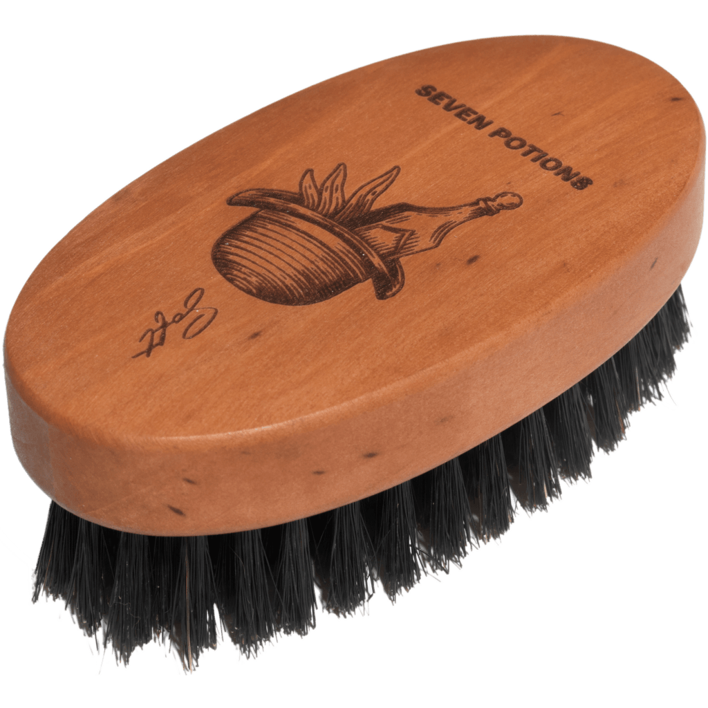Wooden brush with black bristles and 'Seven Potions' branding on a clear background