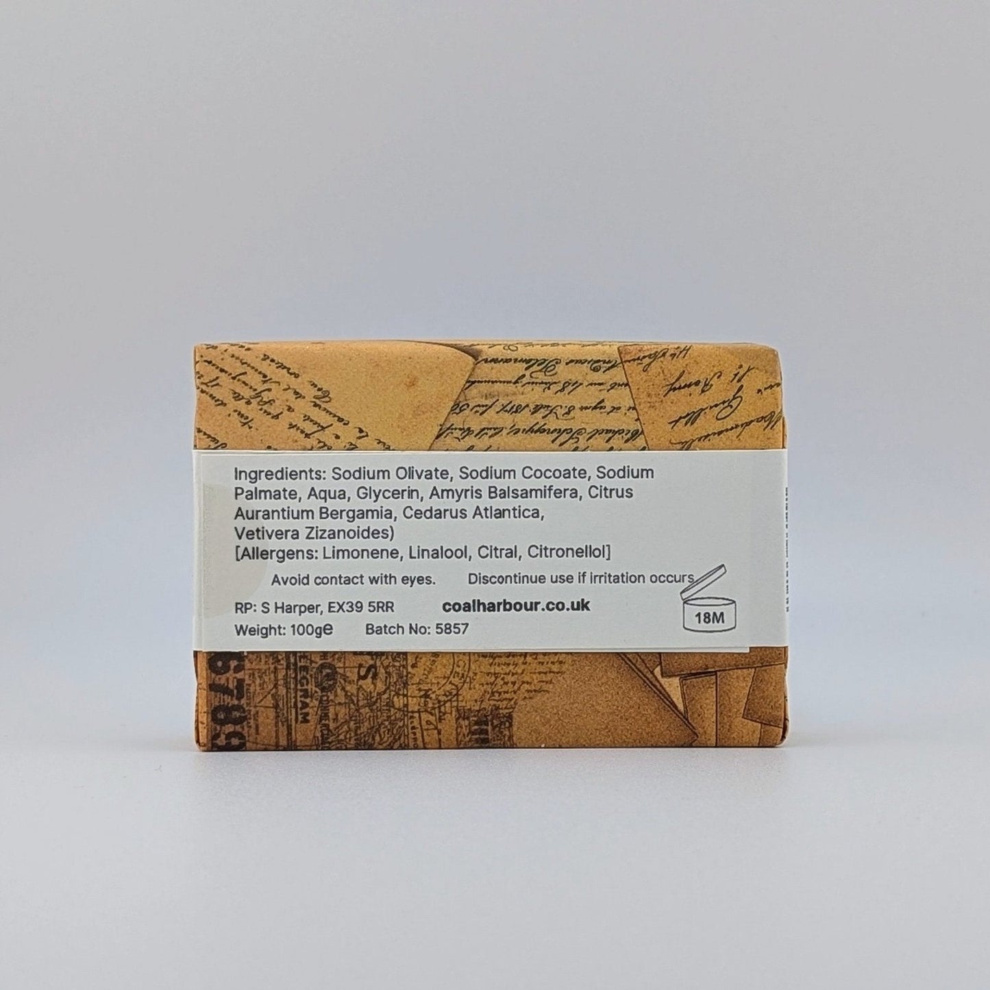 Bar of soap with a brown and white label on a light gray background