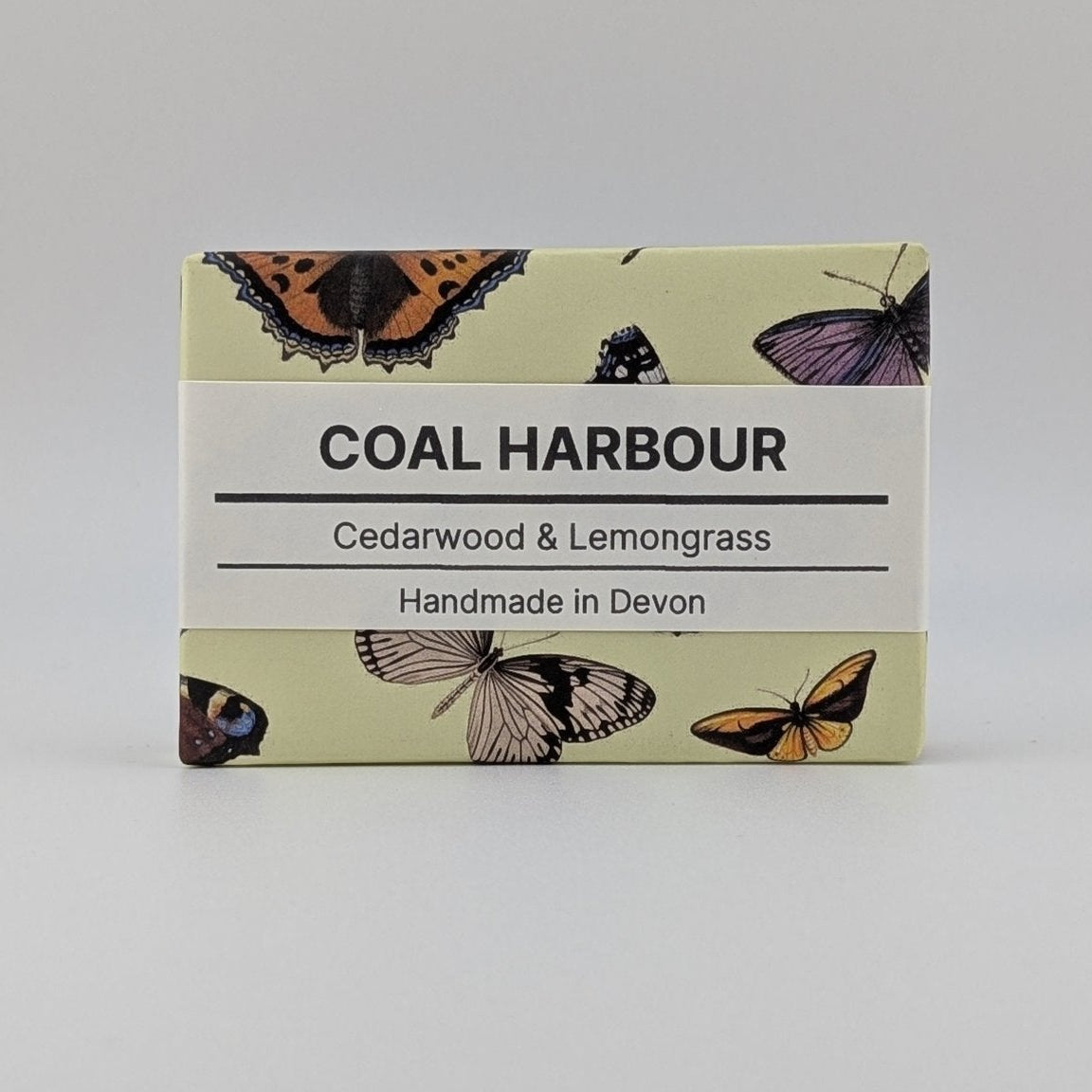 Soap bar with 'Coal Harbour' branding and butterfly illustrations on a light gray background