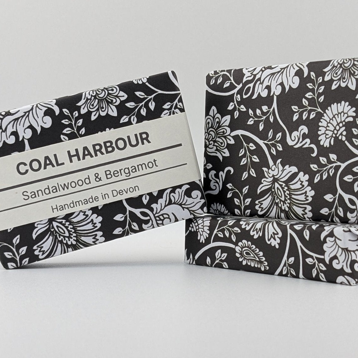 Two soap bars with black and white floral patterns on a light gray background