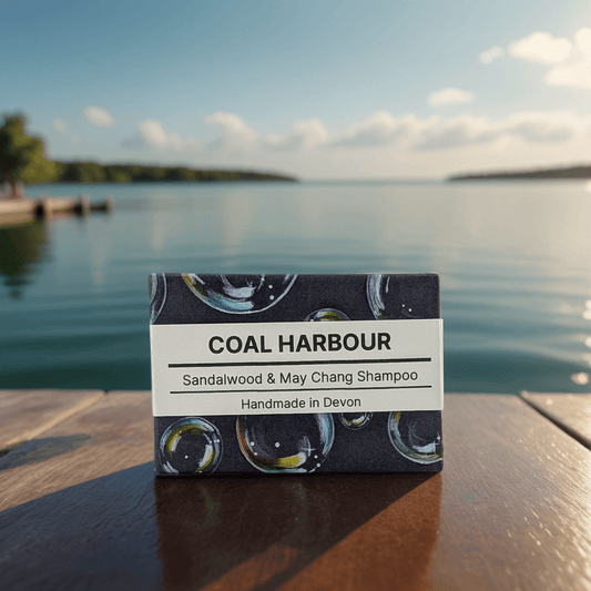 Coal Harbour Sandalwood & May Chang Shampoo bar packaging on a wooden surface with a lake in the background