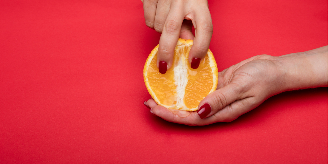 Ladies hands holding a cut orange.