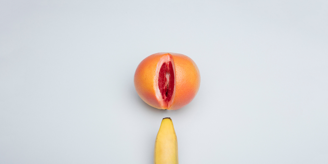 A banana entering the screen below a sliced open orange.