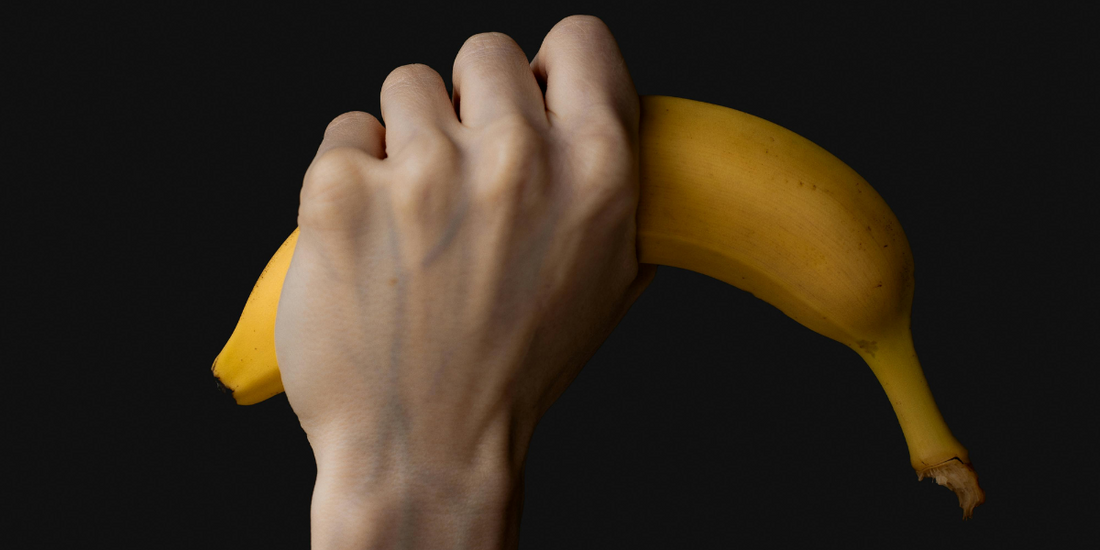 Hand holding a banana.