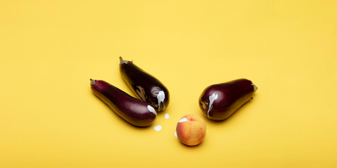 3 eggplant and a peach, with cream dripping from them.