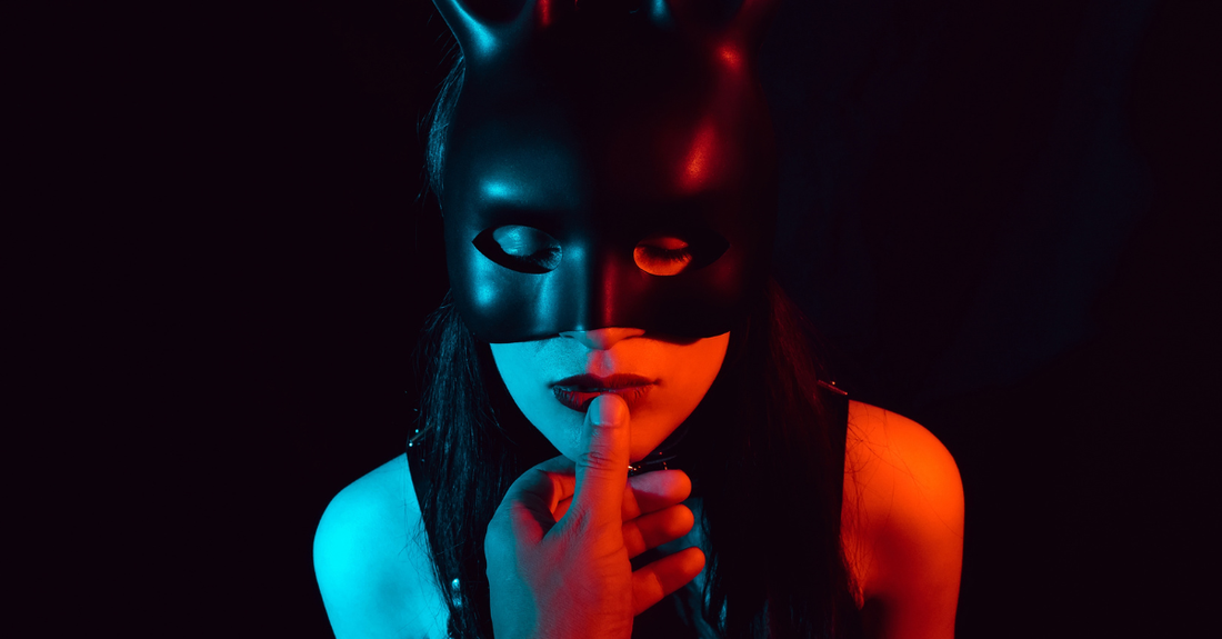 women in bondage helmut with thumb at her mouth on a black background