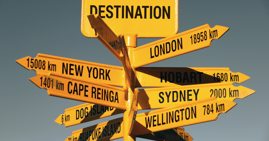 Destination sign with distances to various cities in yellow