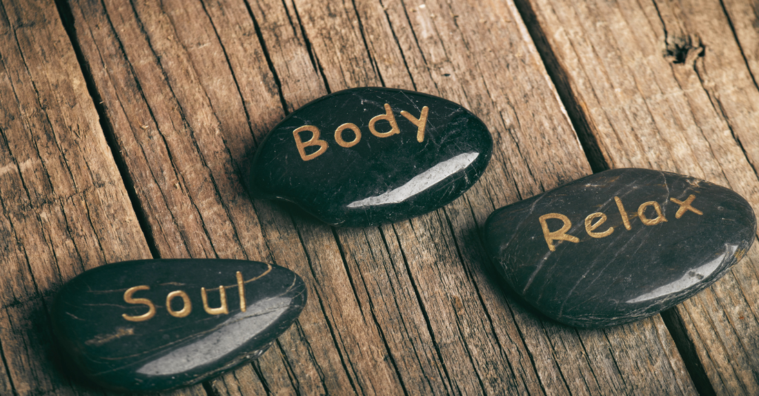 3 stones with words - soul, body, relax on a wooden table