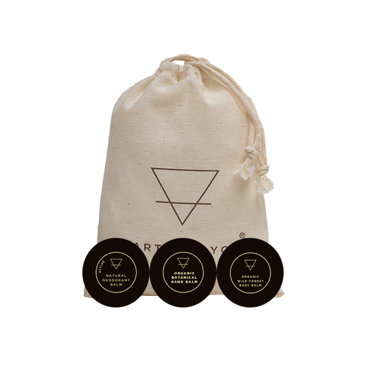 Three organic skin care balm containers with a drawstring bag featuring a logo on a white background.