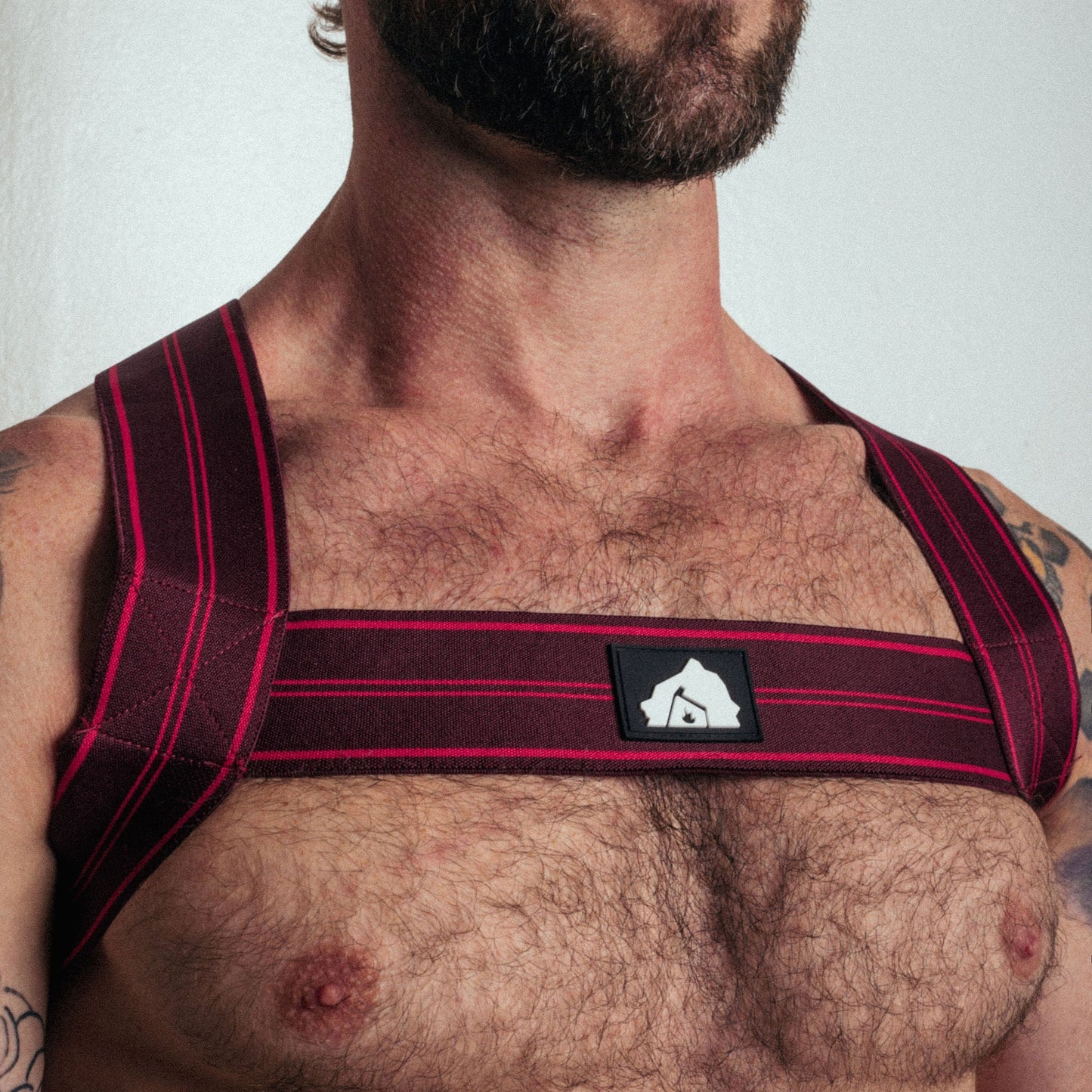 Man wearing a red and black shoulder support brace against a white background