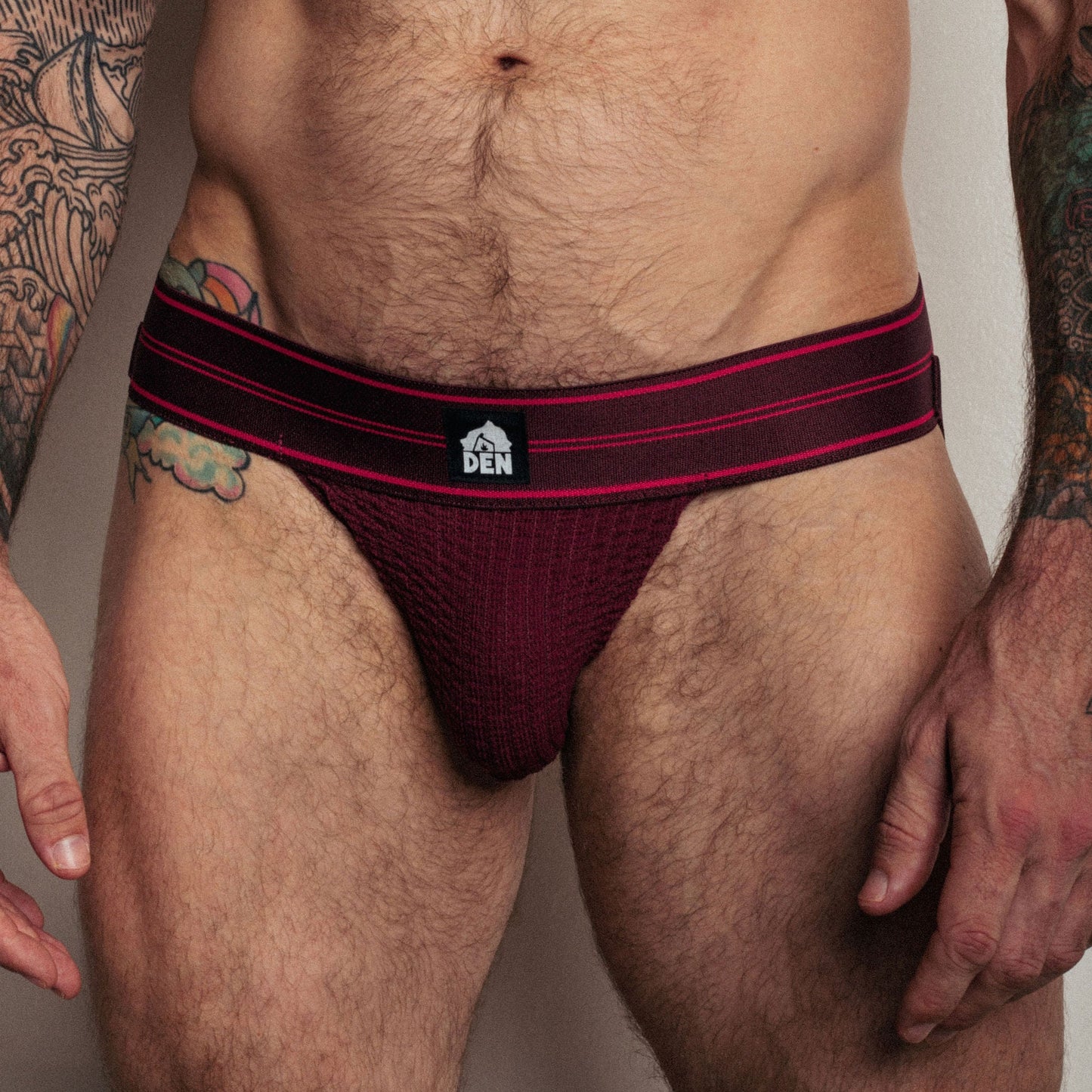 Maroon men's underwear with red waistband on a neutral background