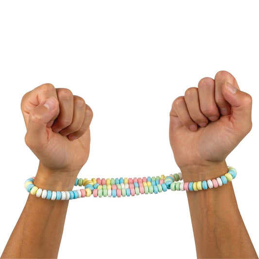 candy handcuffs on a set of hands on white background. image 1