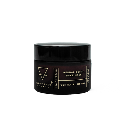 Black jar of herbal detox face mask with brand name on a white background