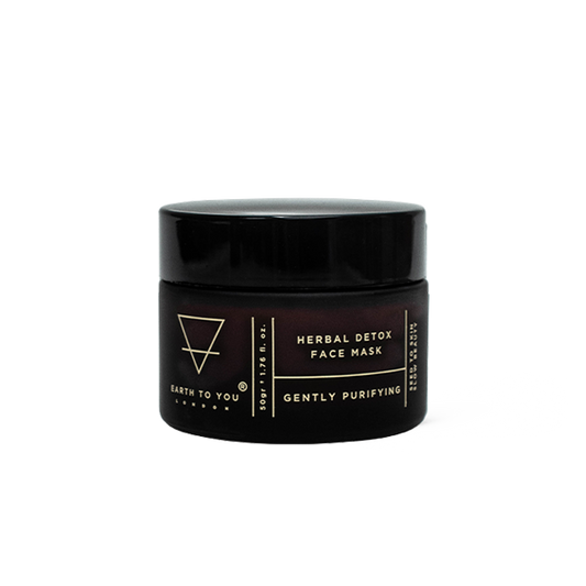 Black jar of herbal detox face mask with brand name on a white background