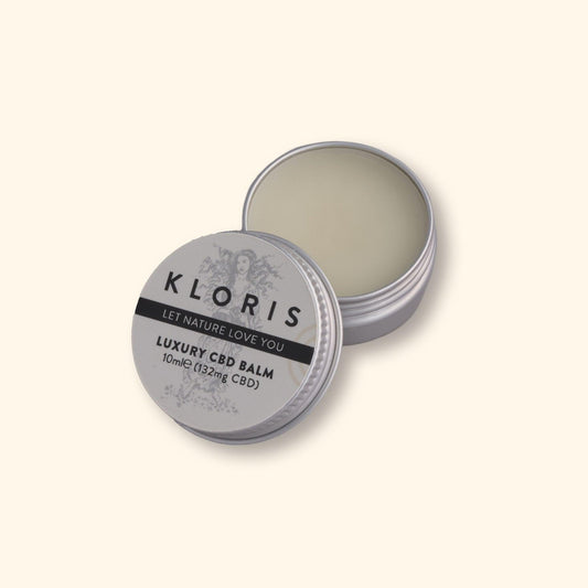 Kloris CBD balm container with lid open on a light beige background
