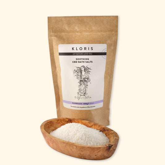 Kloris soaping CBD bath salts packaging with a wooden bowl of bath salts on a white background