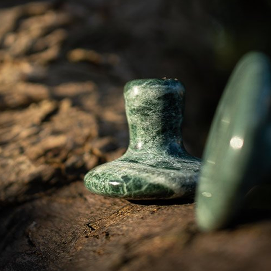 Green stone object on a rocky surface
