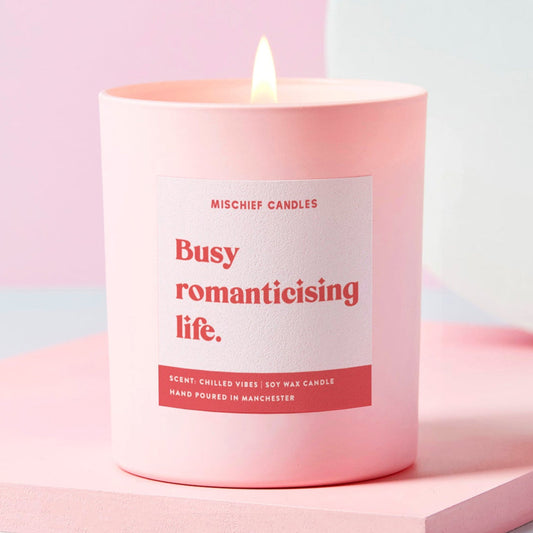Pink candle with a label on a light pink background