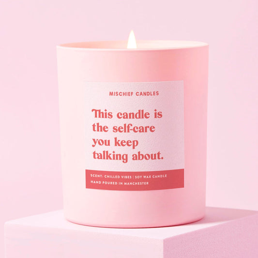 Pink candle with a label on a light pink background