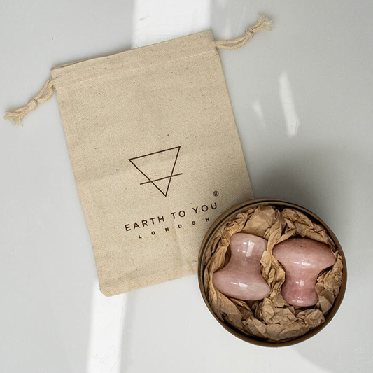 Pink ceramic products in a cardboard box with an Earth to You London drawstring bag on a white background