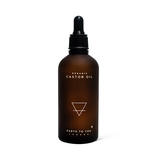 Brown glass bottle with dropper labeled 'Organic Castor Oil' by 'Earth to You London' on a white background