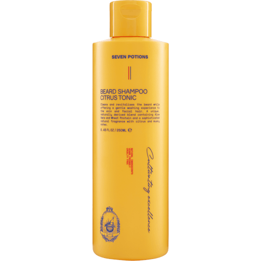 Yellow bottle of Seven Potions beard shampoo on a gray background