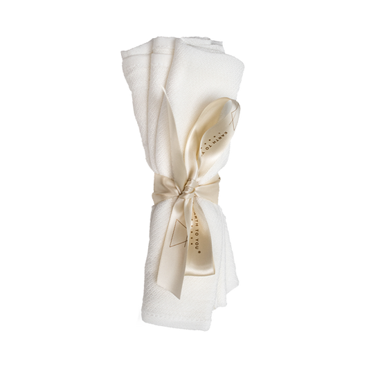 White towel with a gold ribbon on a white background