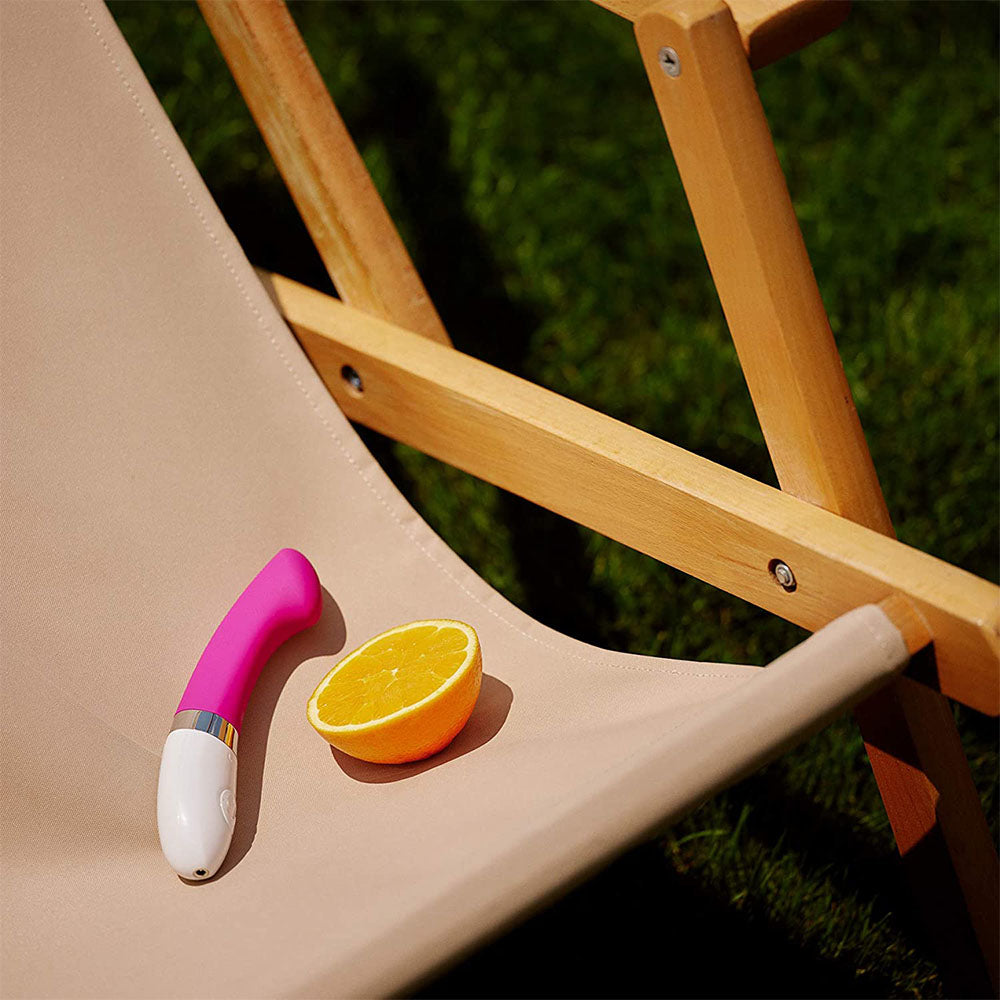 Turquoise Blue G-Spot Vibrator laying on a chair with and orange. image 3