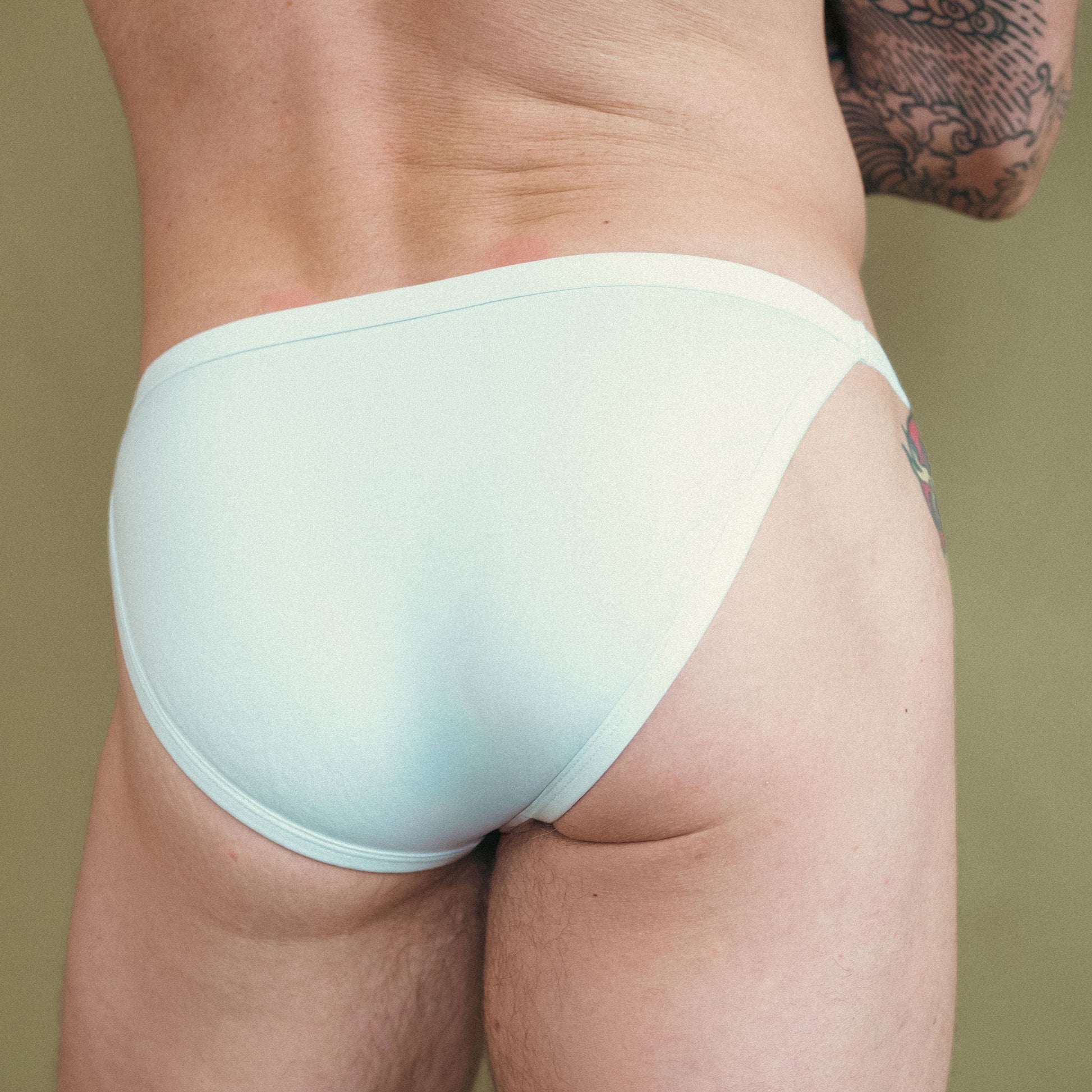Light blue underwear worn by a person on a beige background