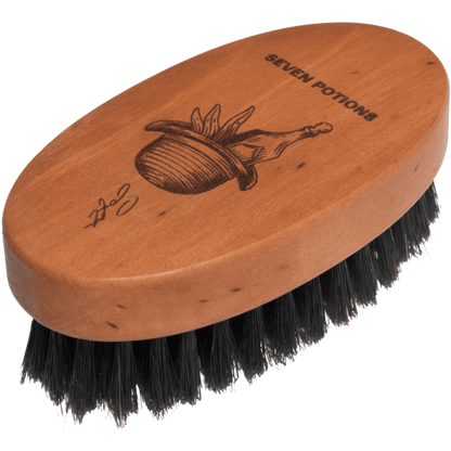 Wooden brush with black bristles and 'Seven Potions' branding on a clear background