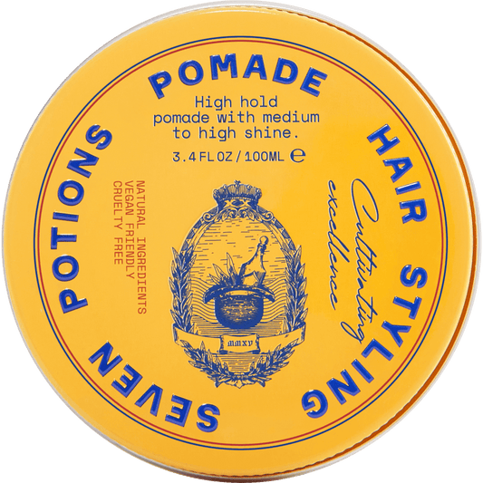 Yellow container of hair pomade with blue text and branding on a gray background