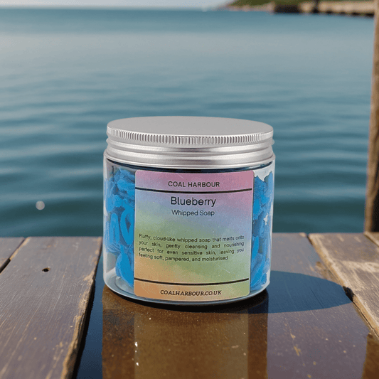 Jar of Blueberry Whipped Soap by Coal Harbour on a wooden surface with water in the background
