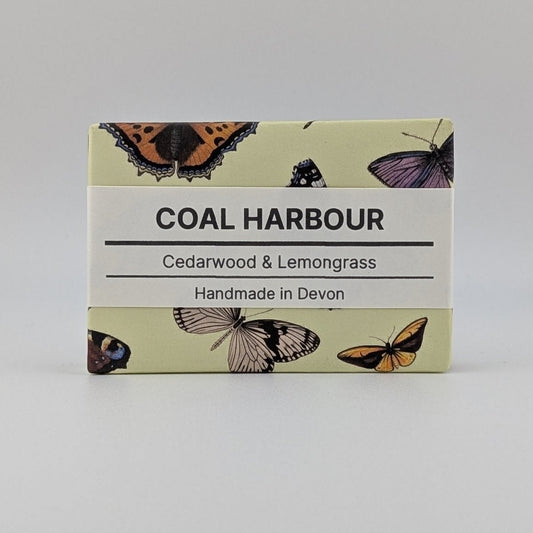 Soap bar with 'Coal Harbour' branding and butterfly illustrations on a light gray background