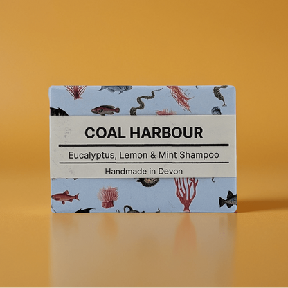 Coal Harbour shampoo bar packaging with a blue label on an orange background