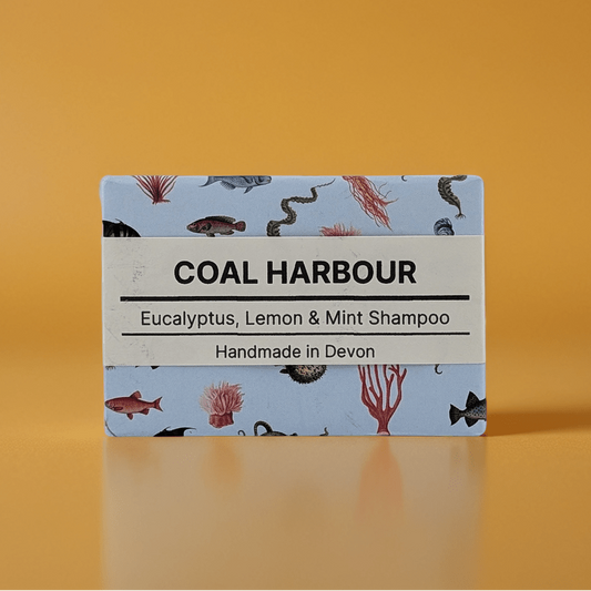 Coal Harbour shampoo bar packaging with a blue label on an orange background