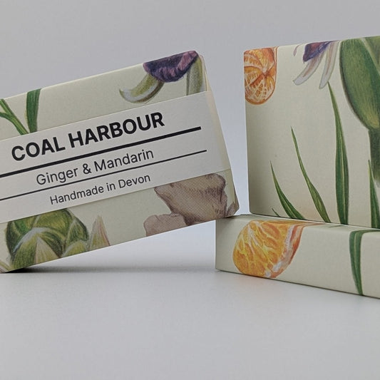 Two bars of soap with floral designs and a label for 'Coal Harbour' on a gray background