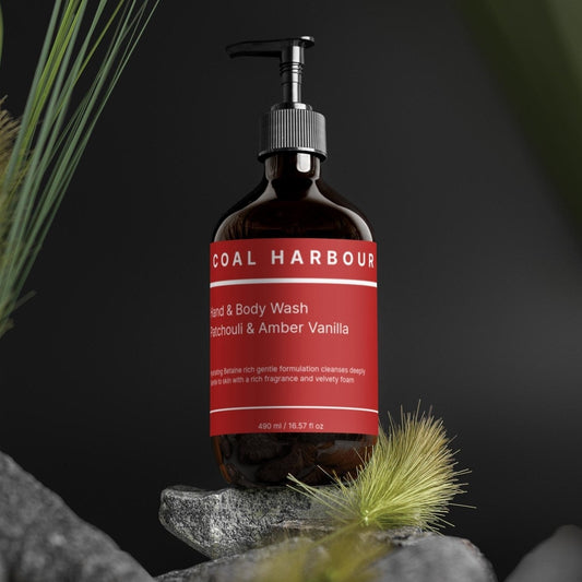 Bottle of Coal Harbour mandarin & amber vanilla soap on a rock with plants in the background