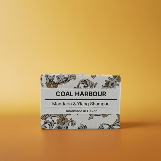Box of Coal Harbour Mandarin & Ylang Shampoo on a gradient orange background