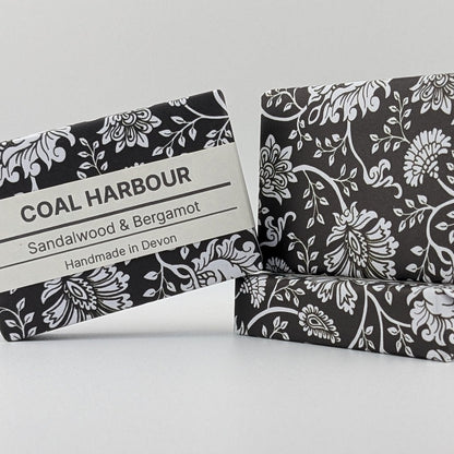 Two soap bars with black and white floral patterns on a light gray background