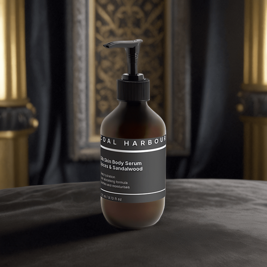Bottle ofunal harmony body serum on a dark surface with a decorative background